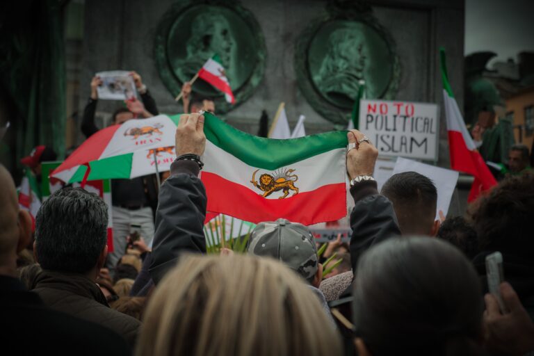 Protest in Stockholm with Iranian flags and social issue slogans.